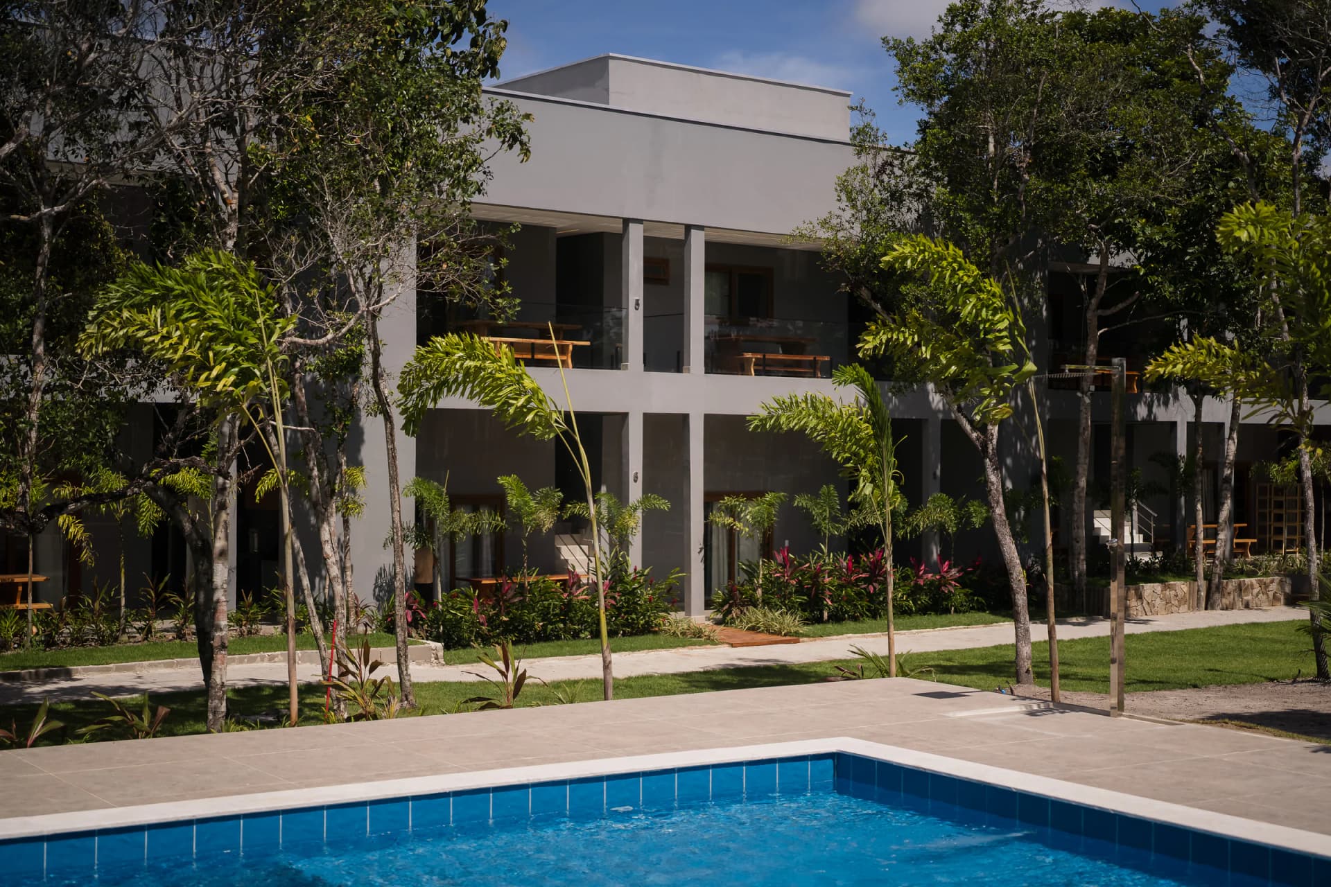 Piscina em primeiro plano e suítes ao fundo no Residencial Marinho, Arraial d’Ajuda.